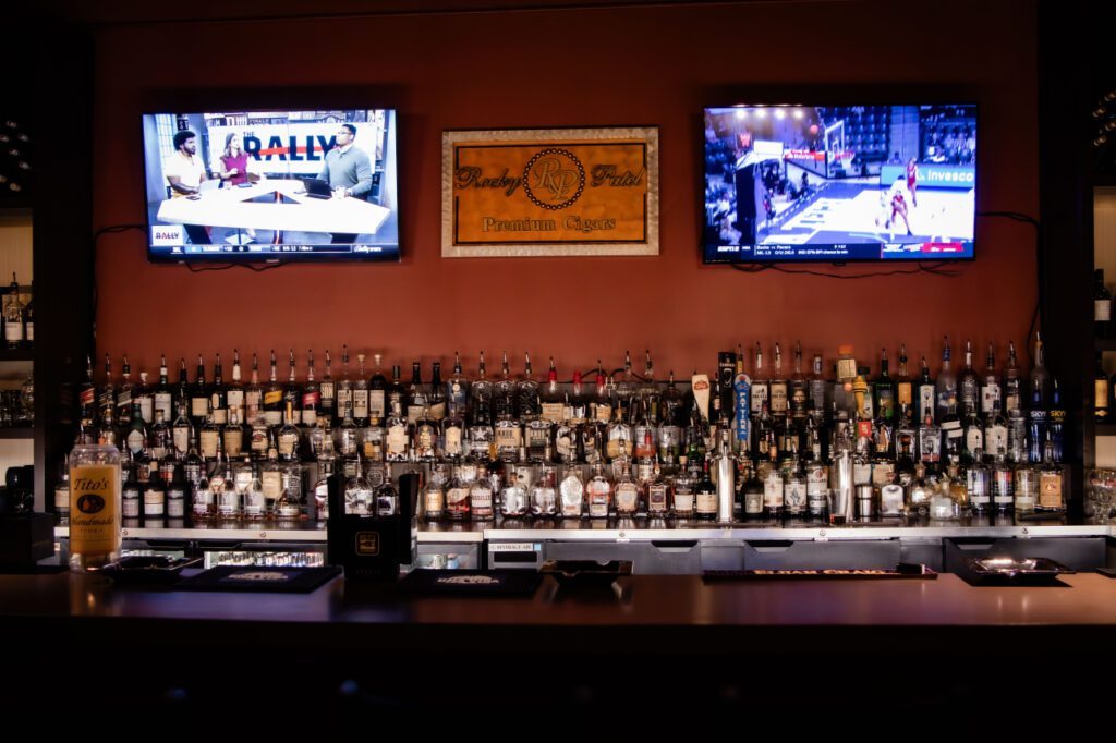 Front view of the Classic Cigars back bar with two TVs above